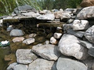Искусственный пруд с мощением верхней ступени камнем